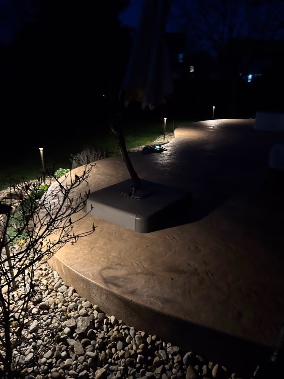Low landscape lights along a curved stone patio